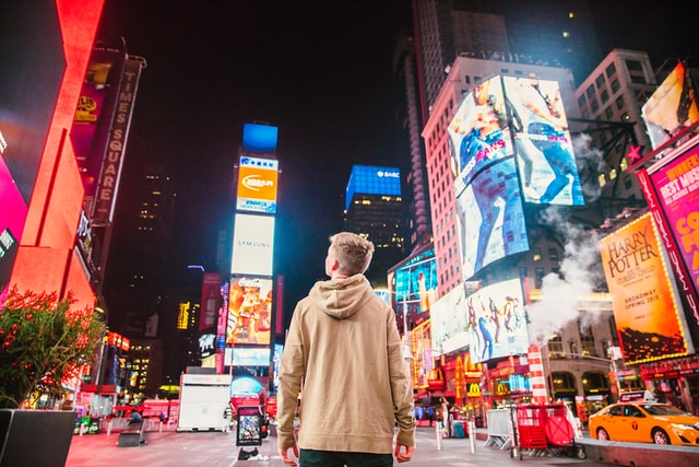 young man standing in the middle of Times Square NYC